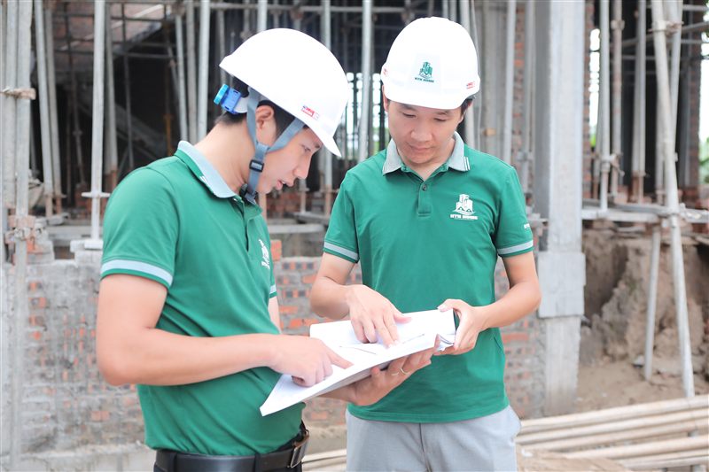 Hai kỹ sư xem hồ sơ thi công